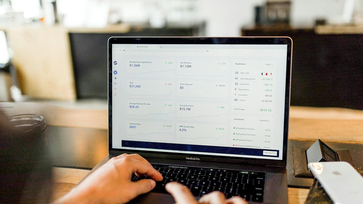 Hands typing on a laptop showing an online store dashboard