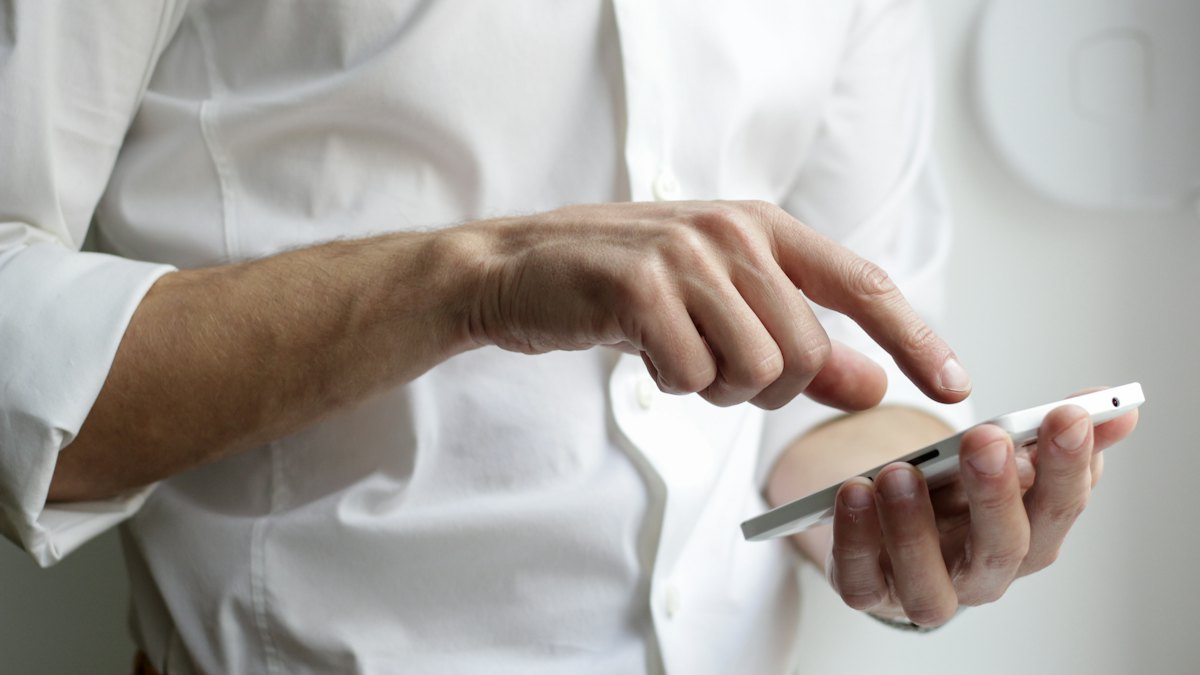 Person tapping a smartphone to compare prices online