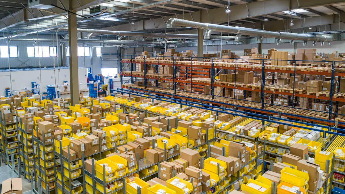 Aisles of packages in a large fulfillment warehouse