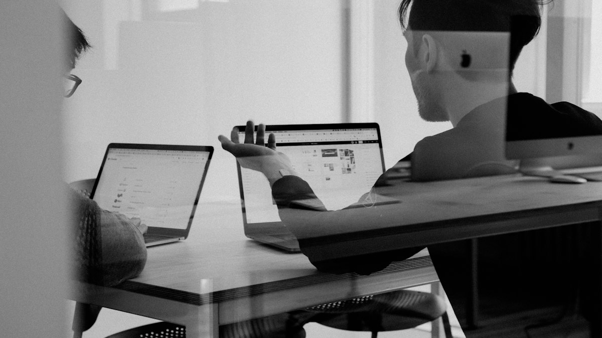 Person working on a laptop, in black and white